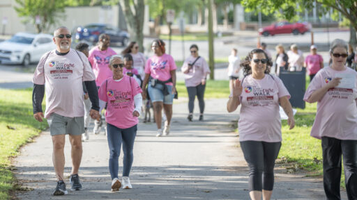 Group of people walking on a path, wearing pink 